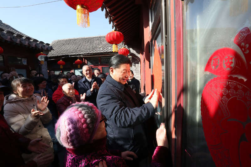 2019年2月1日上午，習(xí)近平在北京前門東區(qū)草廠四條胡同32號院，高興地拿起一幅“福”字，親自貼到門上，給這里的老街坊們拜年。新華社記者 鞠鵬 攝