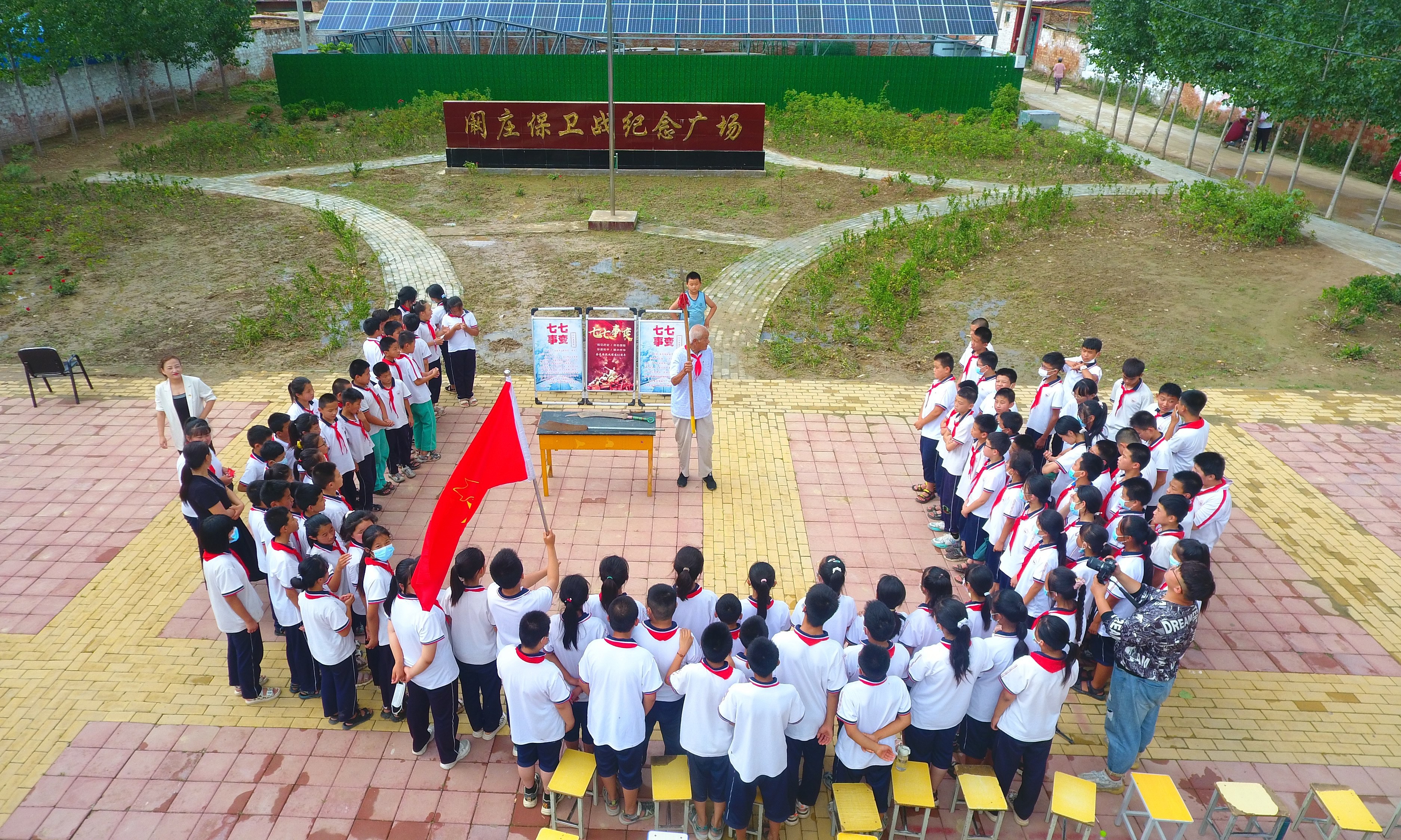 2022年7月6日，山東省聊城市，在茌平區(qū)菜屯鎮(zhèn)闞莊村的闞莊保衛(wèi)戰(zhàn)紀(jì)念廣場，闞莊保衛(wèi)戰(zhàn)親歷者王光木老人，為小學(xué)生們講述抗戰(zhàn)故事，展示大刀、長矛。
